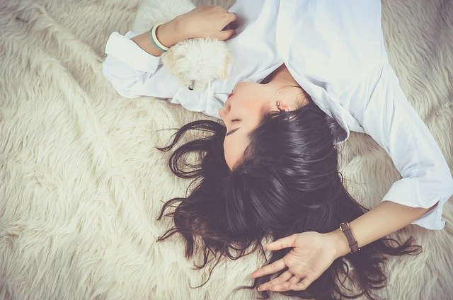 A dog sleeping on a bed with a woman